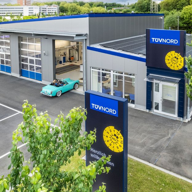 TÜV NORD-Prüfstelle mit türkisfarbenem Oldtimer auf dem Vorplatz